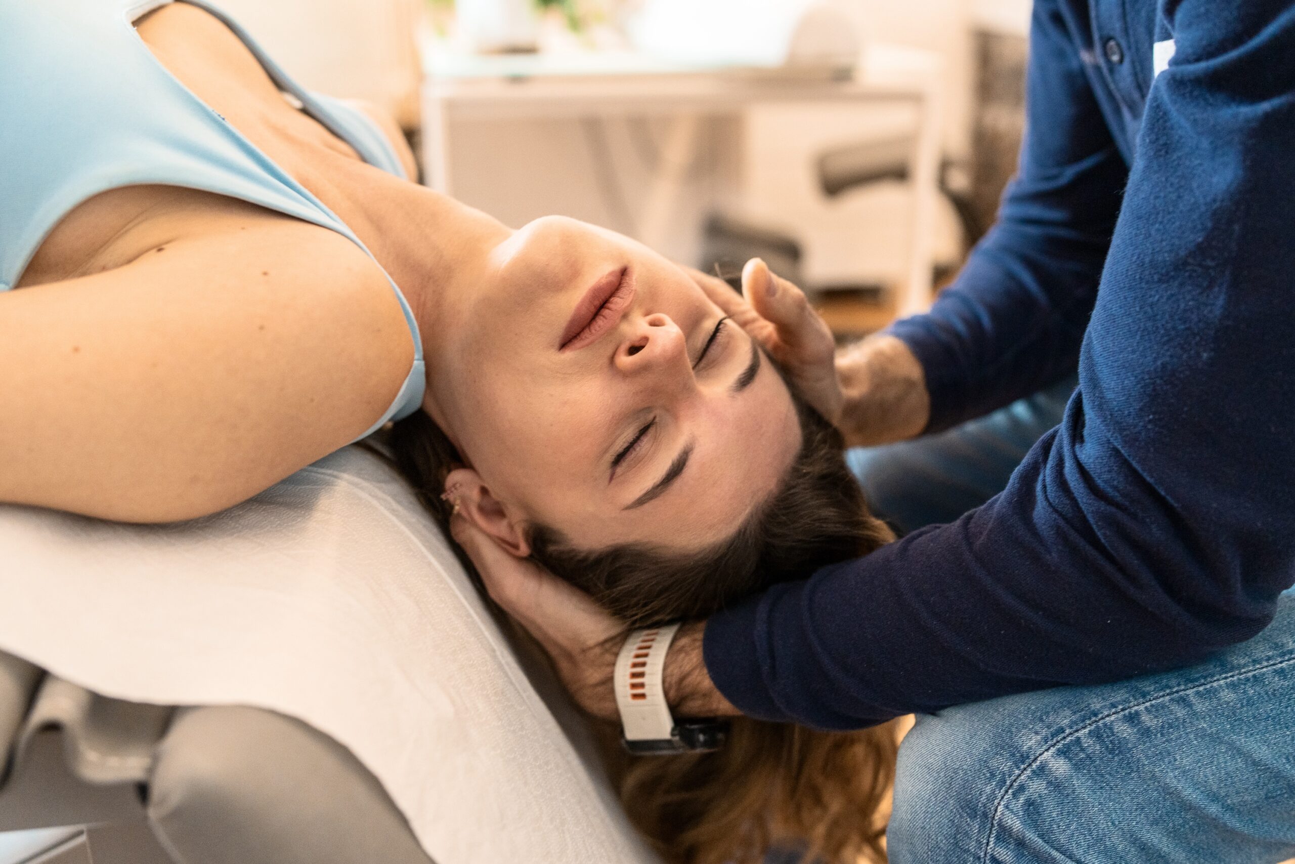 A chiropractor performing a spine adjustment on a woman’s neck to support mobility and spinal alignment at Strive Health & Performance. 