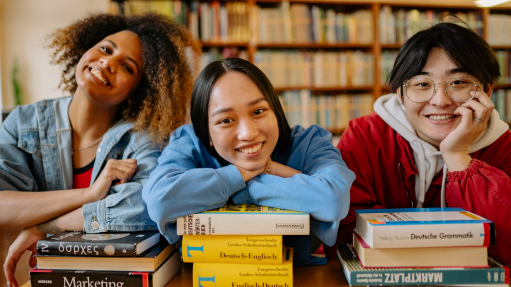 Three teens sit in a library, they are feeling more empowered about their mental health after following the tips from Strive.