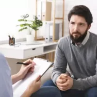 stressed-young-man-talking-to-psychologist-at-ther-2022-12-16-08-10-02-utc-374x240